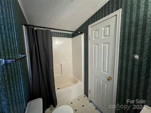 bathroom featuring crown molding, toilet, shower / bathtub combination with curtain, and a textured ceiling