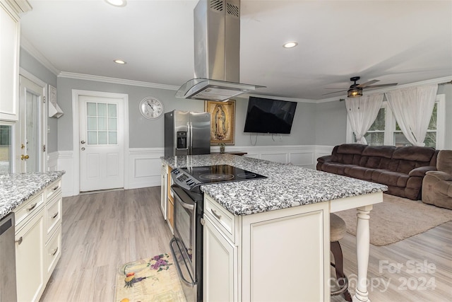 kitchen with light stone counters, appliances with stainless steel finishes, a kitchen bar, a kitchen island, and island exhaust hood