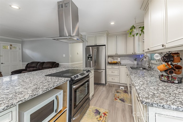 kitchen featuring sink, appliances with stainless steel finishes, light stone countertops, crown molding, and wall chimney range hood