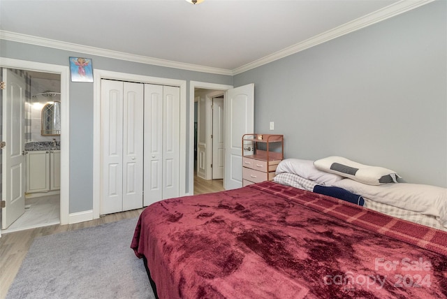 bedroom featuring a closet, light wood-type flooring, ornamental molding, and ensuite bathroom