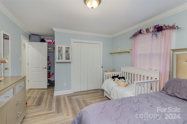 bedroom with crown molding, light parquet floors, and a closet