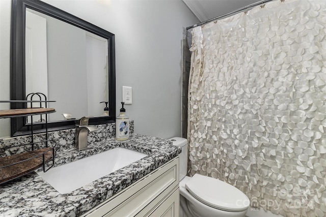 bathroom with toilet, vanity, and crown molding