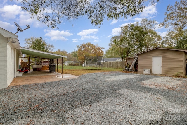 view of yard with a storage unit and a trampoline