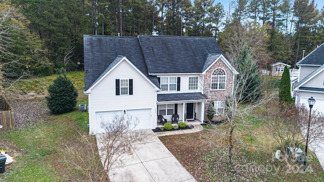 front of property with central AC unit and a garage