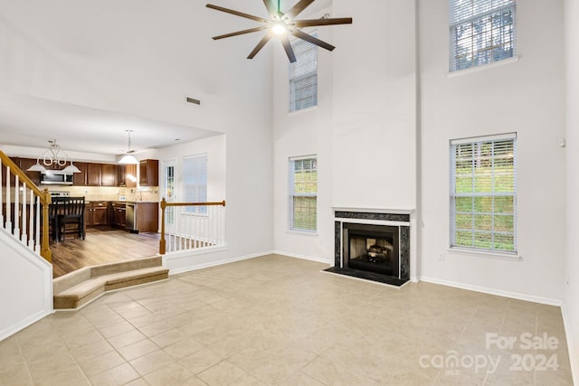 unfurnished living room with light tile patterned flooring and a high ceiling