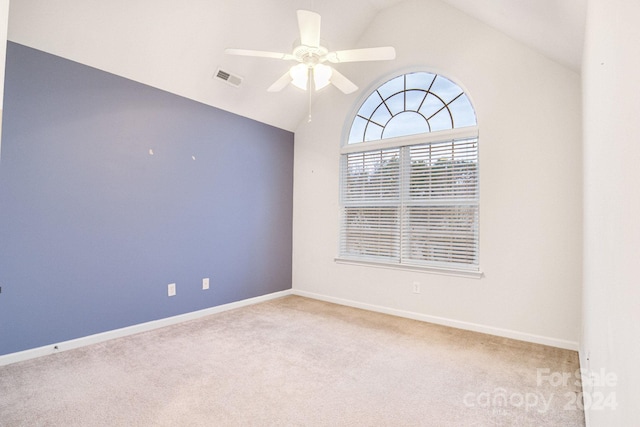 carpeted spare room featuring lofted ceiling and ceiling fan