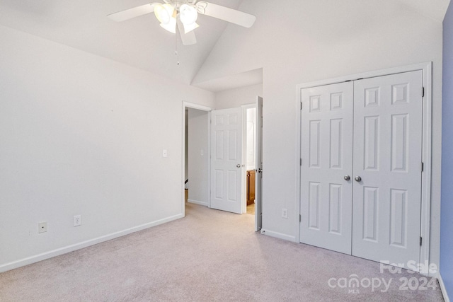 unfurnished bedroom featuring high vaulted ceiling, light colored carpet, ceiling fan, and a closet