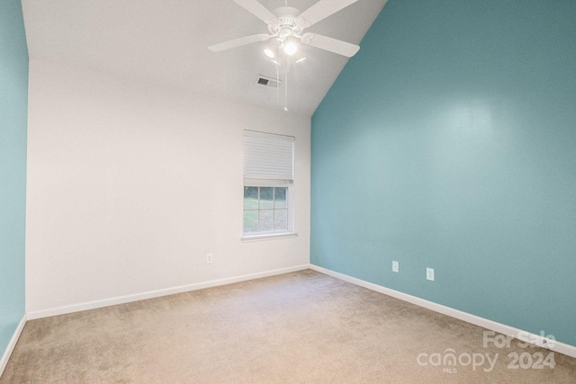 empty room featuring ceiling fan, lofted ceiling, and light colored carpet