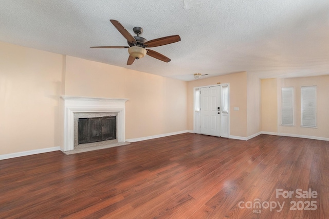 unfurnished living room with dark wood-type flooring, ceiling fan, and a textured ceiling