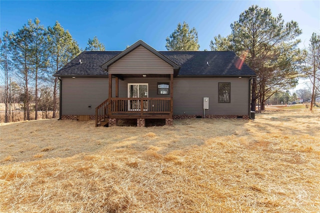 rear view of property featuring a lawn and a wooden deck