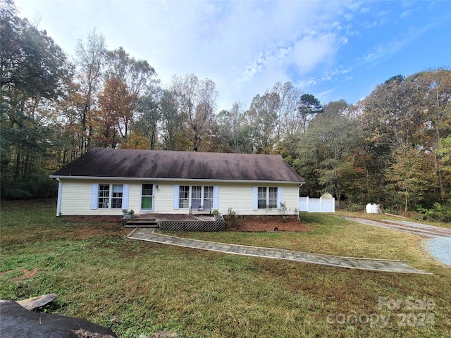 ranch-style home with a deck and a front yard