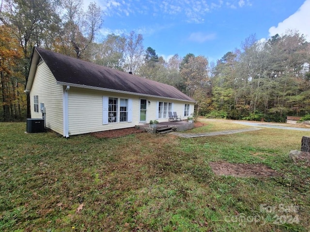 view of front of property with central AC unit, a front lawn, and a deck