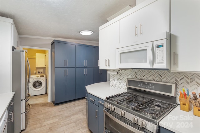 kitchen with white cabinets, stainless steel appliances, washer / clothes dryer, and blue cabinets