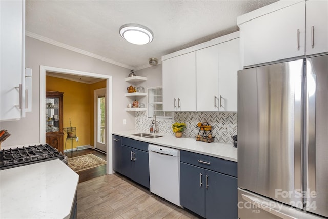 kitchen with white dishwasher, white cabinets, blue cabinetry, stainless steel refrigerator, and light hardwood / wood-style flooring