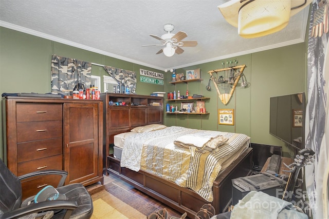 bedroom featuring ornamental molding, hardwood / wood-style floors, a textured ceiling, and ceiling fan