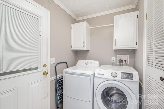 clothes washing area with cabinets, washer and dryer, a textured ceiling, and ornamental molding