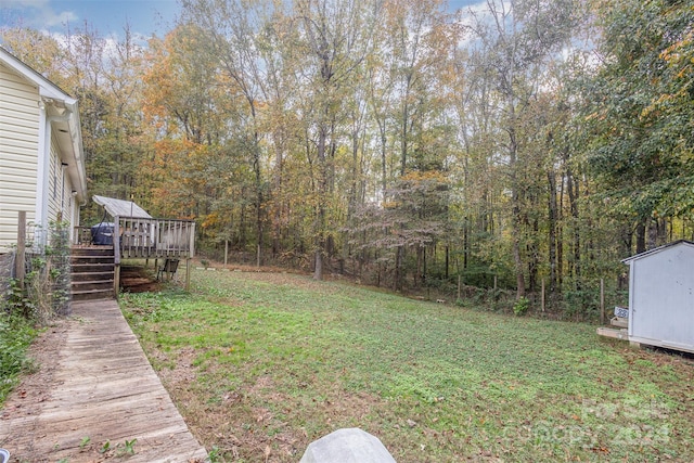 view of yard featuring a storage unit and a deck