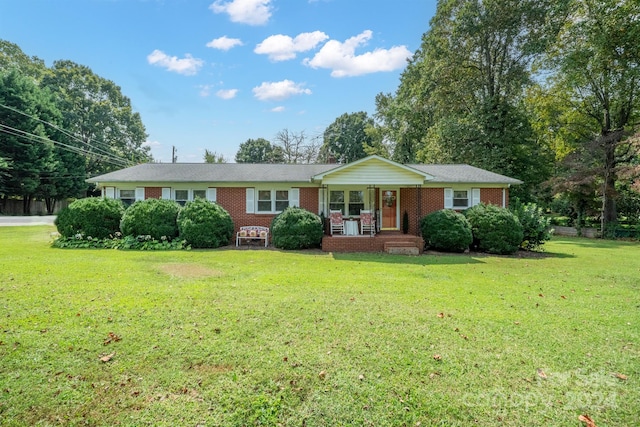 ranch-style house featuring a front yard and covered porch