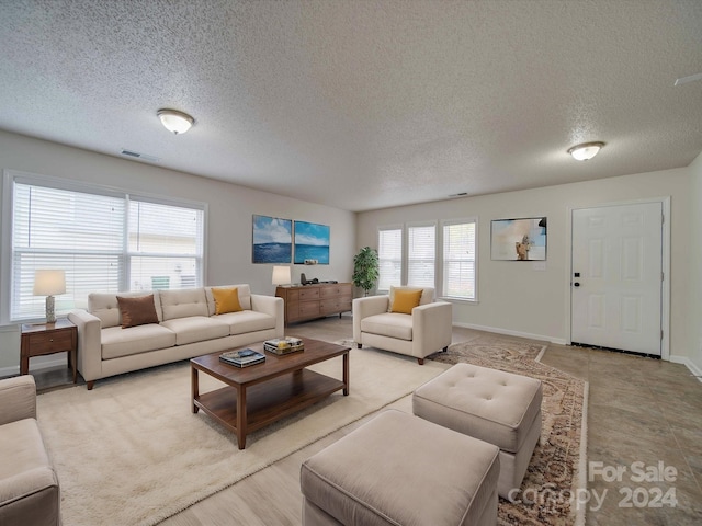 living room featuring plenty of natural light, light tile patterned floors, and a textured ceiling