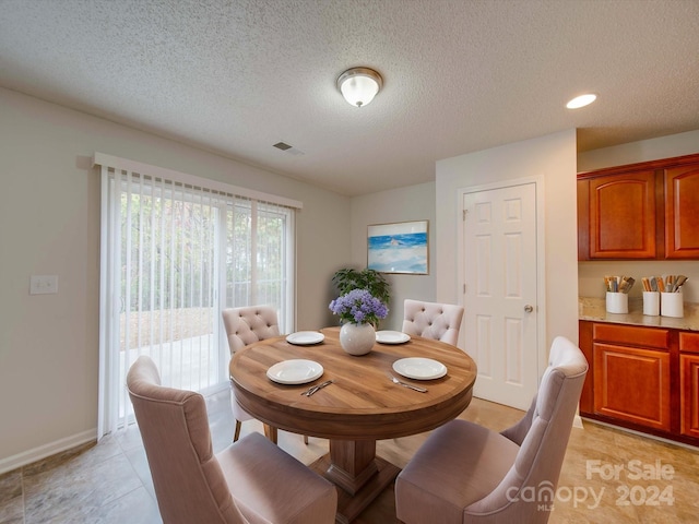 dining room with light tile patterned floors and a textured ceiling