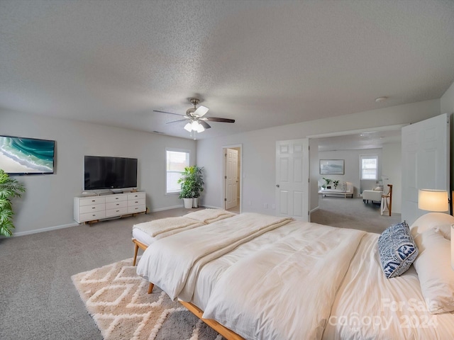 carpeted bedroom featuring a textured ceiling and ceiling fan