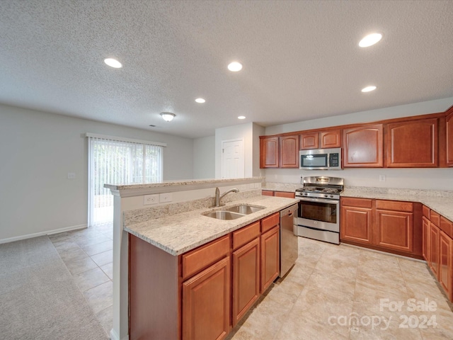 kitchen featuring sink, a textured ceiling, light tile patterned flooring, light stone counters, and stainless steel appliances