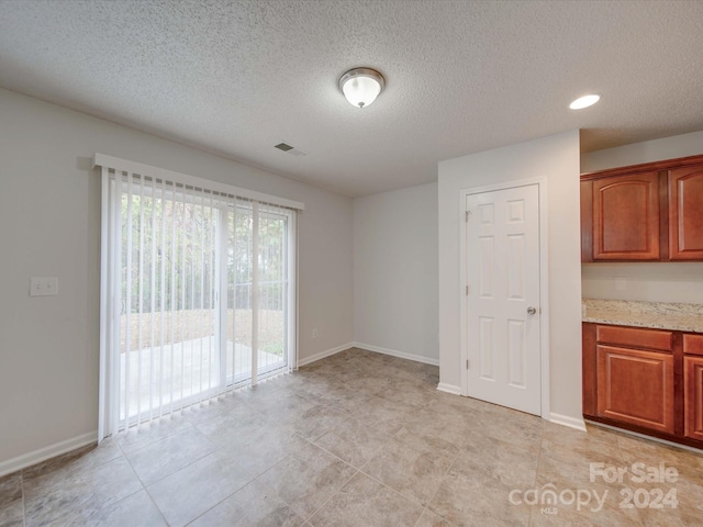 interior space with light tile patterned floors and a textured ceiling