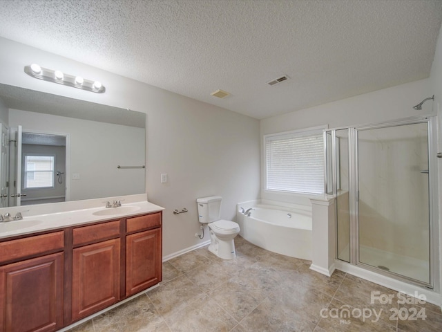 full bathroom featuring vanity, toilet, a textured ceiling, and independent shower and bath