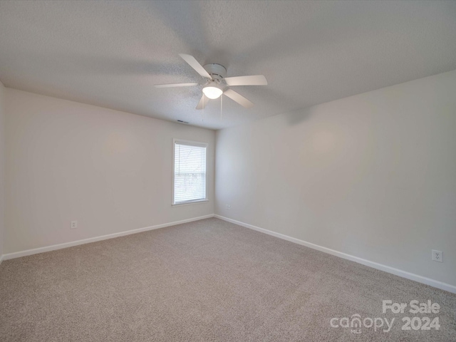 carpeted empty room with a textured ceiling and ceiling fan