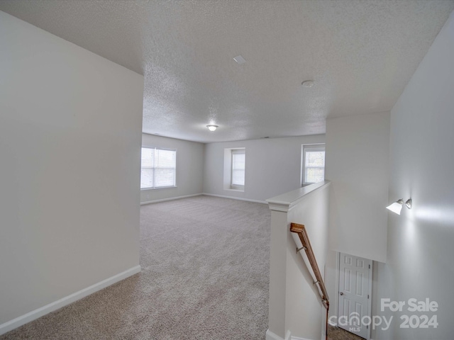 spare room with carpet flooring and a textured ceiling