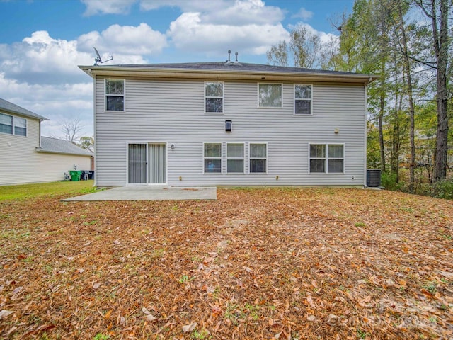 back of property with central AC unit and a patio