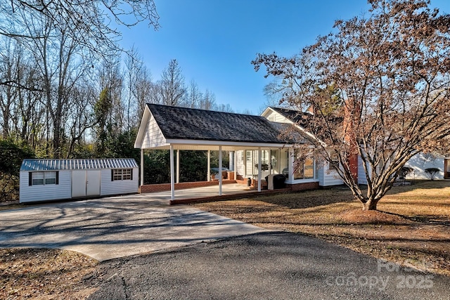 view of front of home featuring a porch, an outbuilding, and a front yard