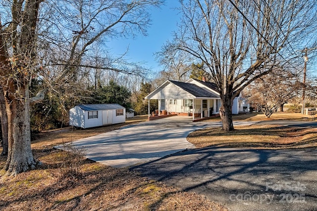 view of front of home featuring a porch and a storage shed