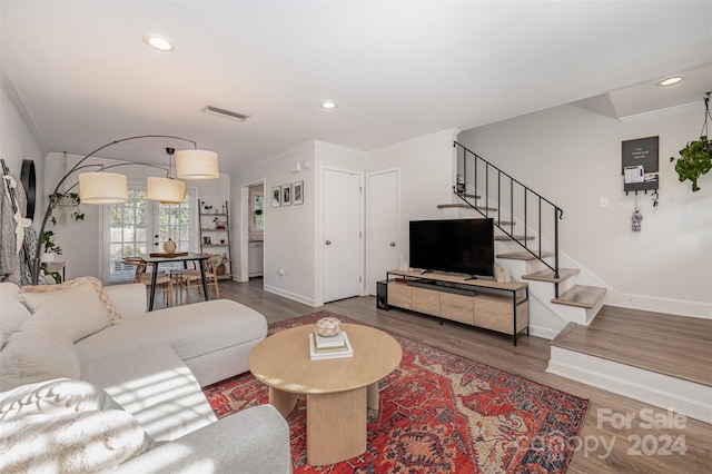 living room with dark hardwood / wood-style flooring and crown molding