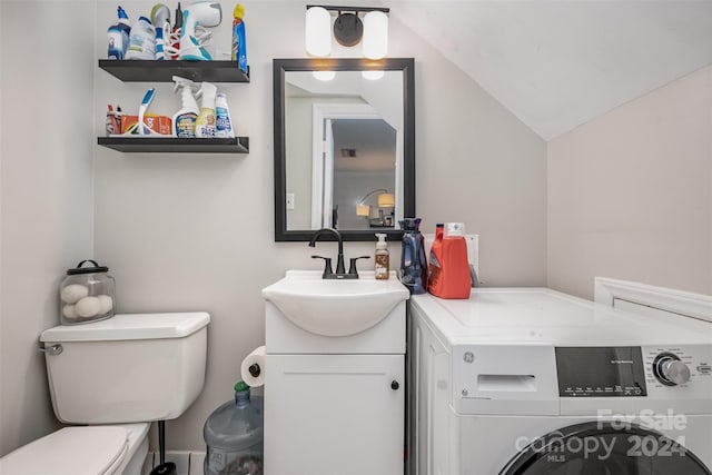 bathroom featuring vaulted ceiling, vanity, toilet, and washer / clothes dryer