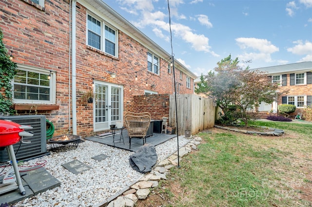 back of house featuring central AC unit, a patio area, and a lawn