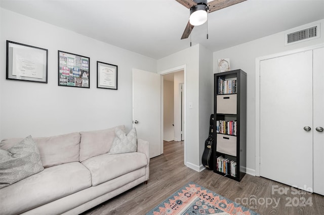 living room featuring hardwood / wood-style floors and ceiling fan