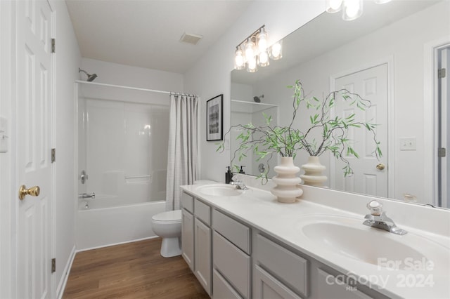 full bathroom with hardwood / wood-style floors, vanity, toilet, and shower / bath combination with curtain