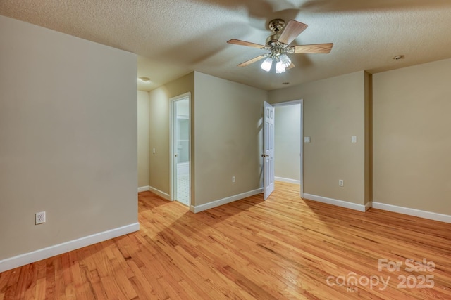 spare room featuring light wood-type flooring, ceiling fan, and a textured ceiling