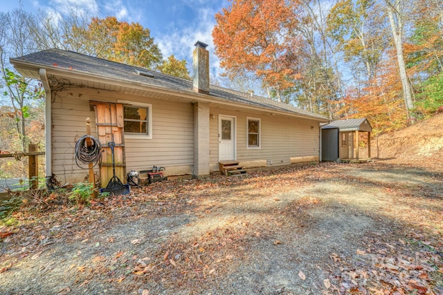 back of house featuring a shed