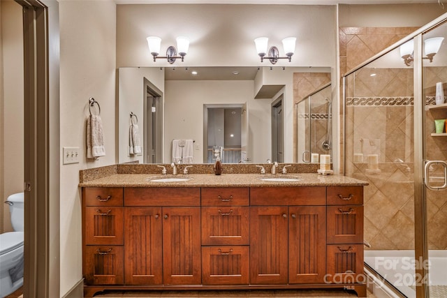 bathroom with walk in shower, vanity, and toilet