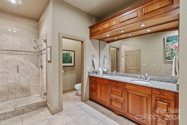 bathroom with tile patterned floors, vanity, toilet, and a shower with shower door