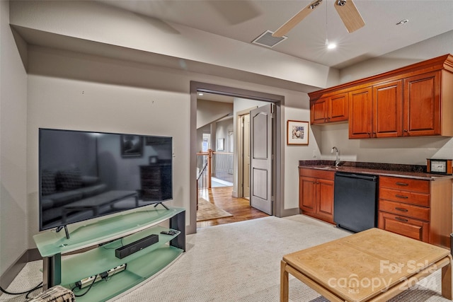 kitchen featuring sink, light hardwood / wood-style flooring, ceiling fan, and black dishwasher