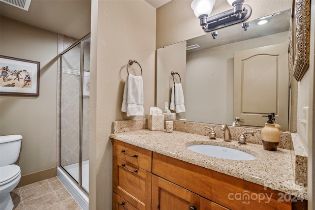 bathroom with tile patterned floors, toilet, vanity, and walk in shower