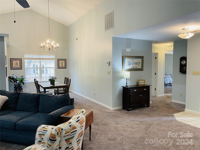 carpeted living room with ceiling fan with notable chandelier and high vaulted ceiling