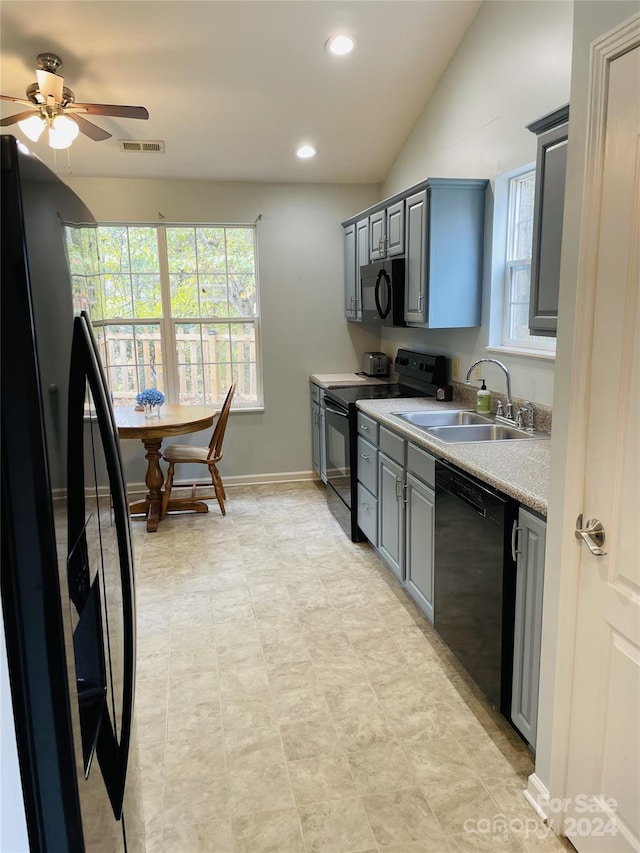 kitchen with sink, black appliances, ceiling fan, gray cabinets, and vaulted ceiling