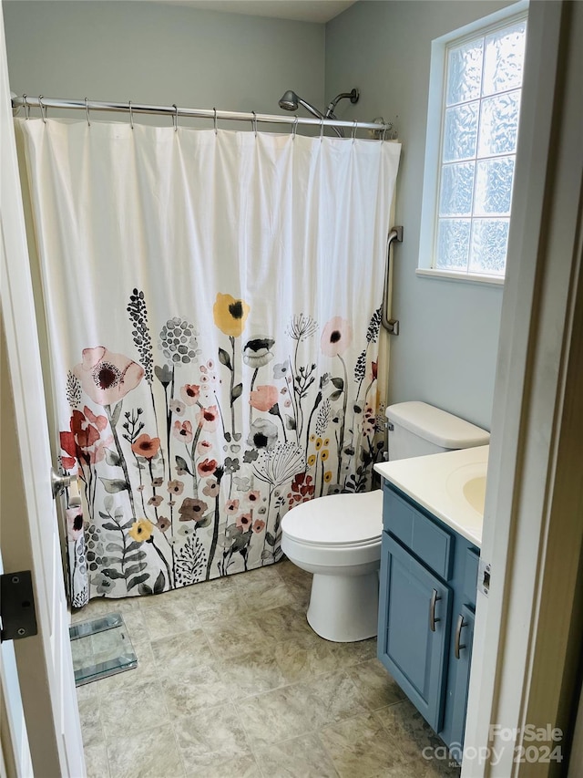 bathroom featuring a shower with curtain, vanity, and toilet