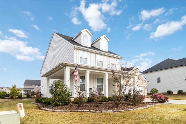 view of front of property with a front lawn, a garage, and covered porch