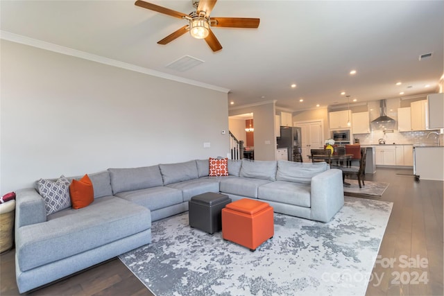 living room featuring ceiling fan, sink, light wood-type flooring, and crown molding