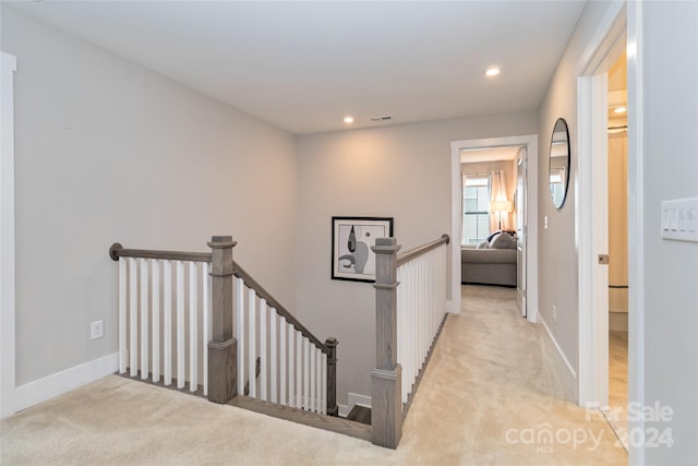 hall featuring light colored carpet